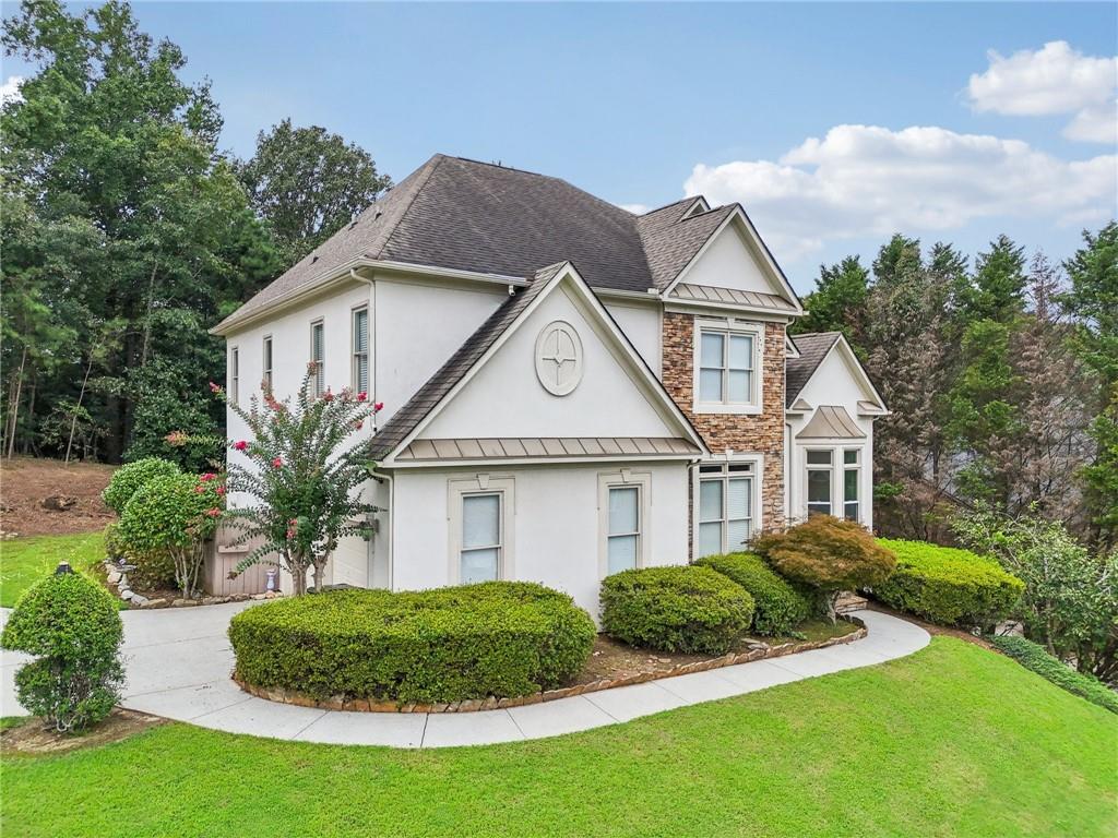 3540 Hickory Branch Trail Suwanee, GA 30024 - Photo 4 of 69 a view of a white house next to a yard with plants and large trees