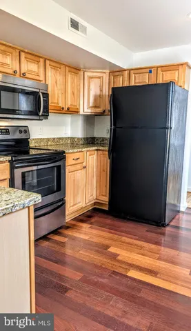 a kitchen with stainless steel appliances granite countertop a refrigerator and a stove top oven