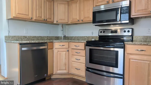 a kitchen with stainless steel appliances granite countertop a stove microwave and oven