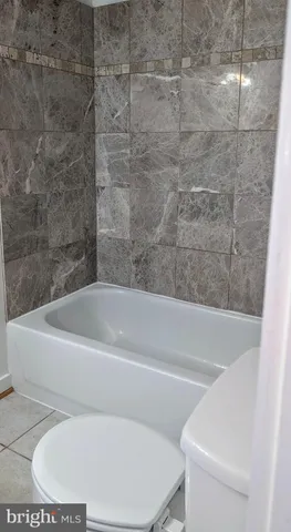 a white bath tub sitting next to a white toilet and sink
