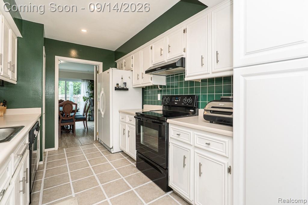 104 Manor Way Rochester, MI 48309 - Photo 19 of 53 Kitchen with white cabinetry, green tile backsplash, and light-colored countertops