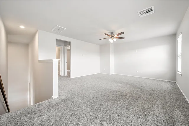 an empty room with a window and a ceiling fan