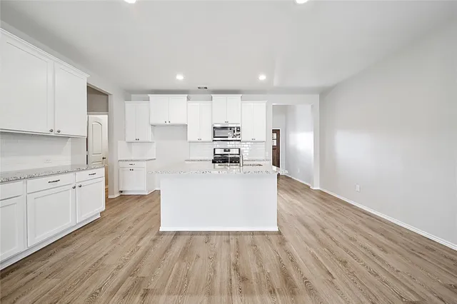 a kitchen with granite countertop a stove and a sink