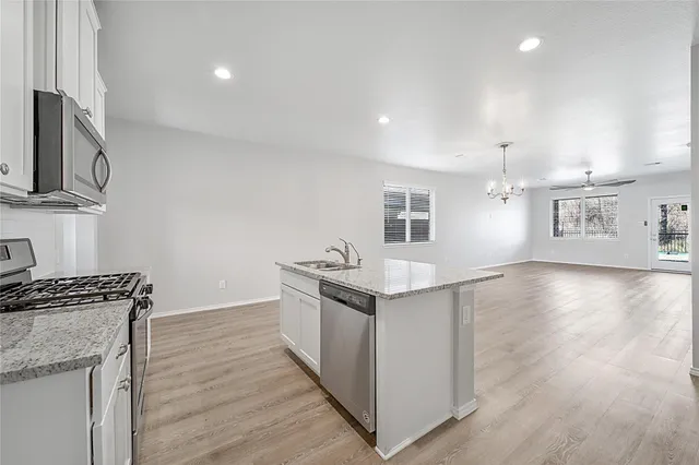 a kitchen with stainless steel appliances granite countertop a white cabinets and wooden floor