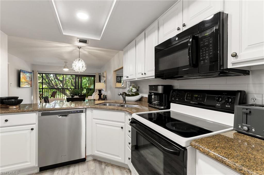 600 Neapolitan Way, Unit 257 Naples, FL 34103 - Photo 11 of 35 a kitchen with a stove microwave and sink
