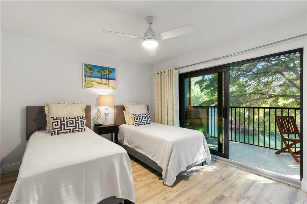 600 Neapolitan Way, Unit 257 Naples, FL 34103 - Photo 15 of 35 a bedroom with two beds and a large window