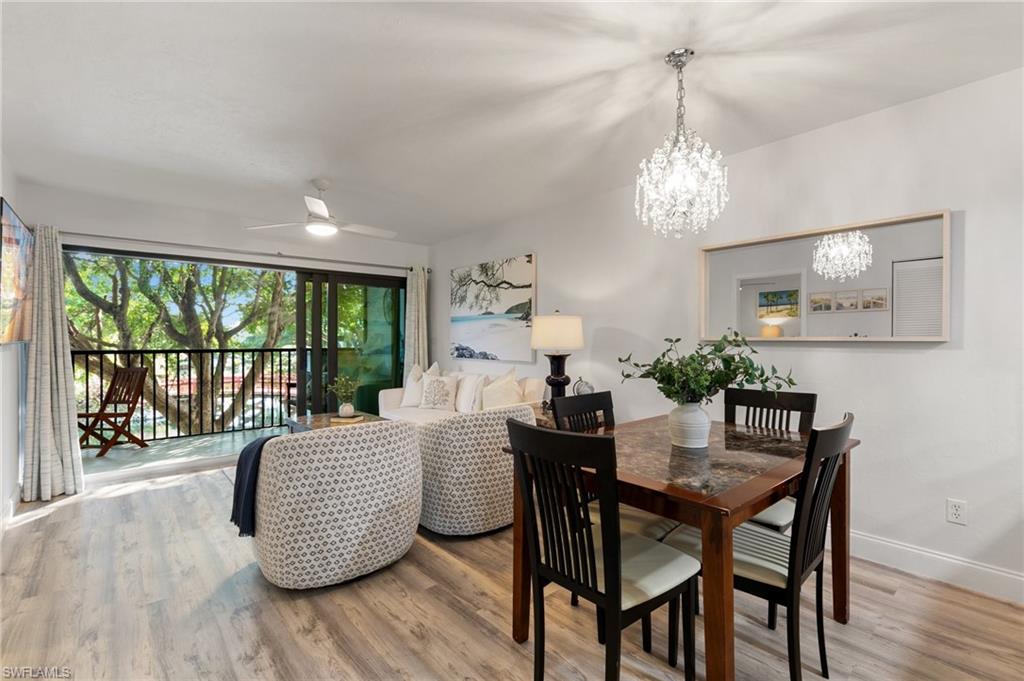 600 Neapolitan Way, Unit 257 Naples, FL 34103 - Photo 7 of 35 a view of a dining room with furniture window and wooden floor