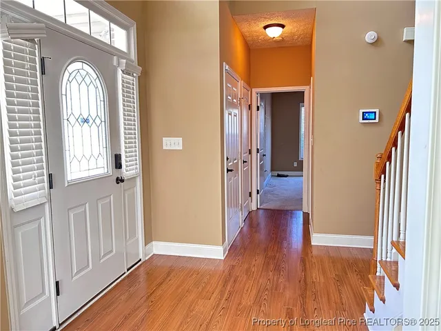 a view of a hallway with wooden floor and glass door
