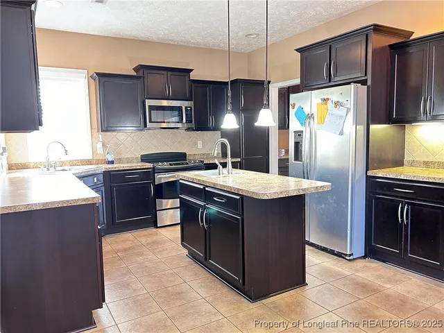 a kitchen with stainless steel appliances granite countertop a stove a refrigerator and a sink