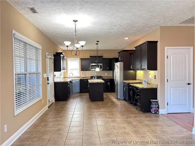 a large kitchen with a large counter top appliances and cabinets