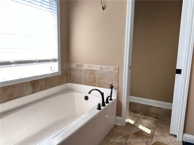 a bathroom with bathtub and window