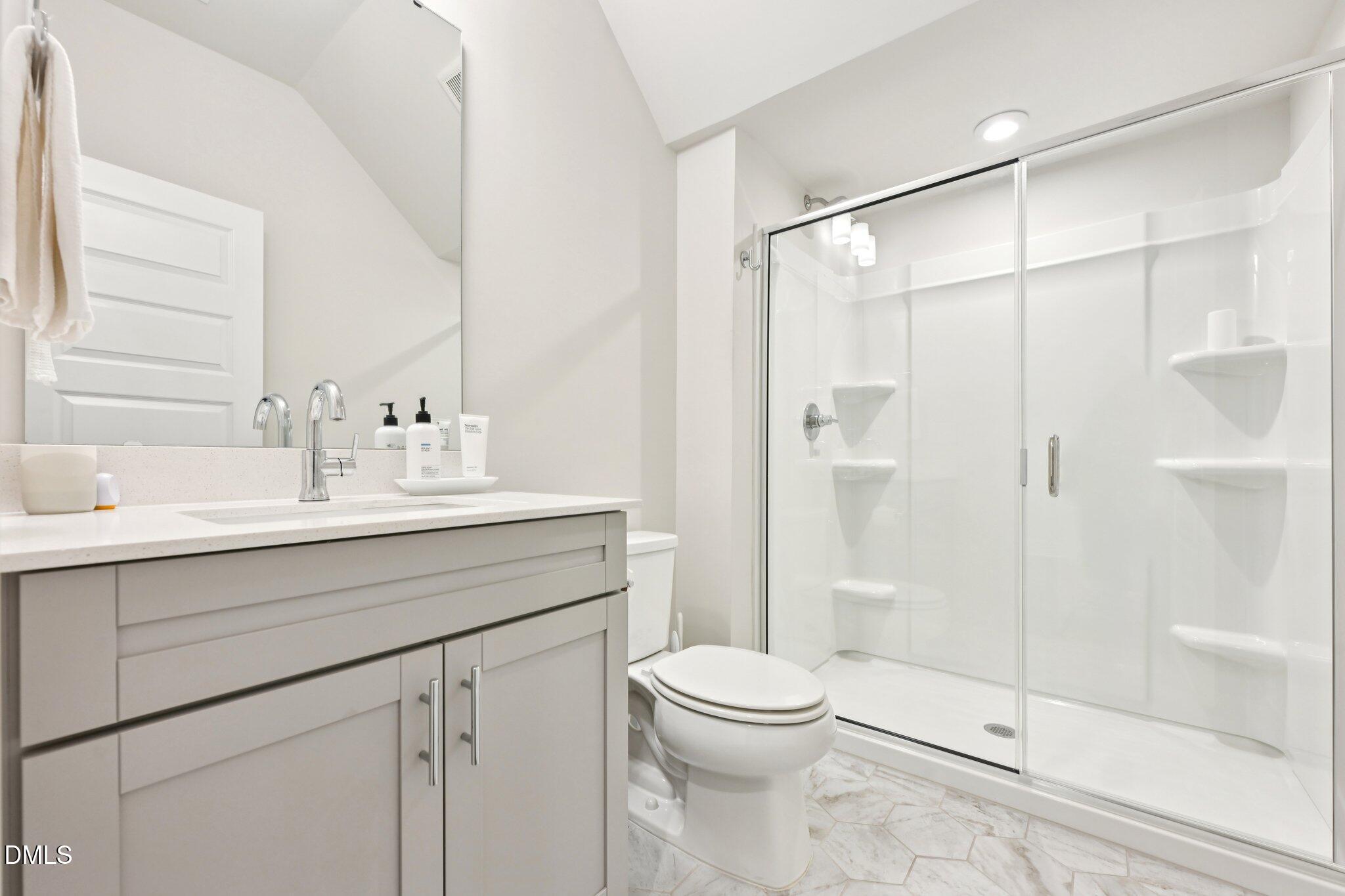 1237 Remey Avenue Wake Forest, NC 27587 - Photo 14 of 40 a bathroom with a shower sink vanity mirror and toilet