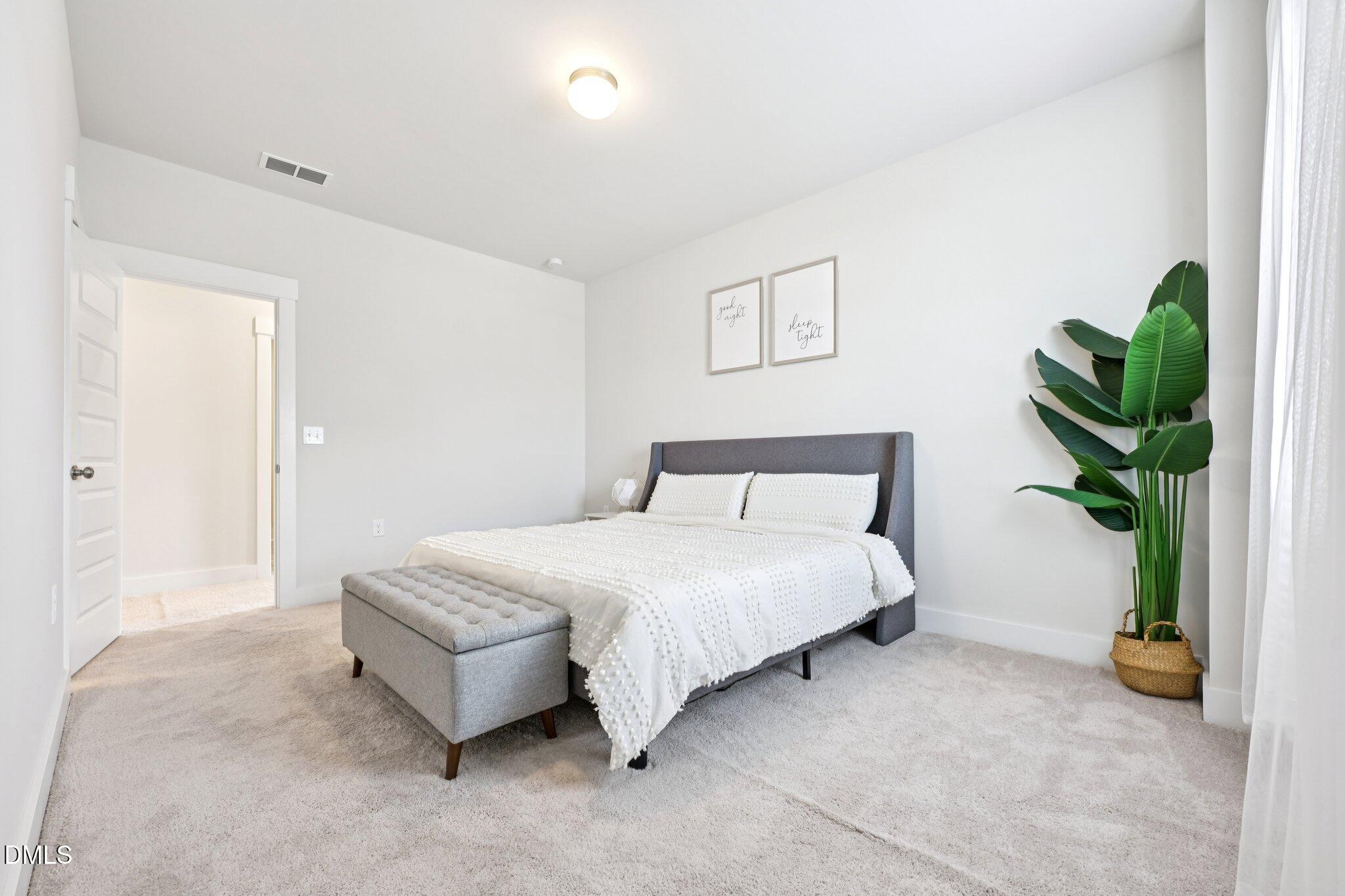 1237 Remey Avenue Wake Forest, NC 27587 - Photo 25 of 40 a bedroom with a bed and a potted plant