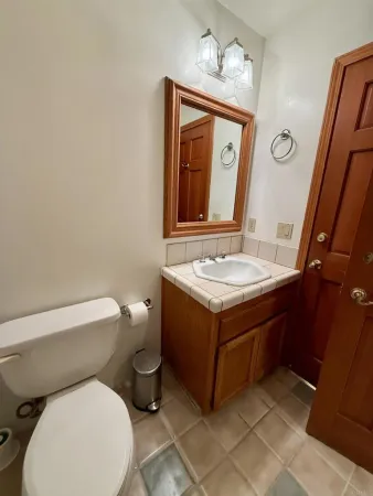 a bathroom with a toilet sink and mirror