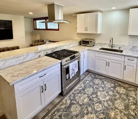 a kitchen with stainless steel appliances granite countertop a stove a sink and a microwave