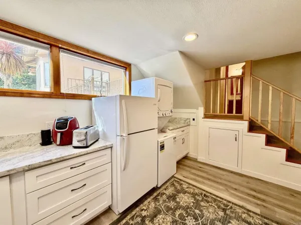 a kitchen with granite countertop white cabinets and white appliances