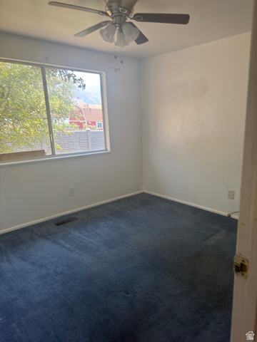 992 300 East Orem, UT 84057 - Photo 7 of 7 Room featuring a ceiling fan with light fixture, white walls, and blue carpet flooring