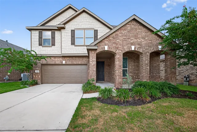 a front view of a house with a garden and plants