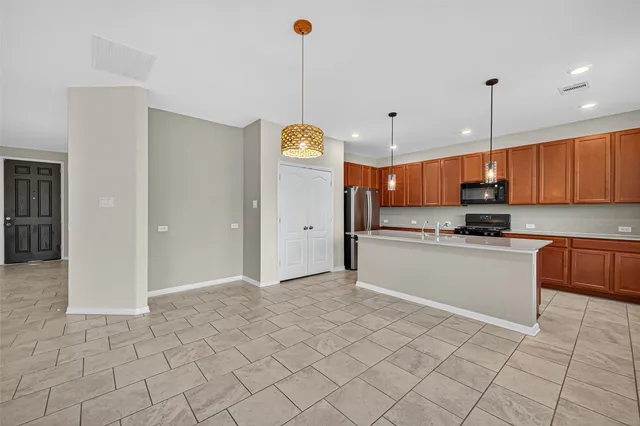 a kitchen with stainless steel appliances granite countertop a refrigerator a sink and a stove