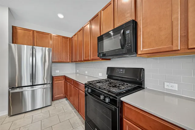 a kitchen with stainless steel appliances granite countertop a refrigerator stove top oven and sink