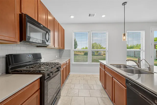 a kitchen with stainless steel appliances granite countertop a sink stove and cabinets