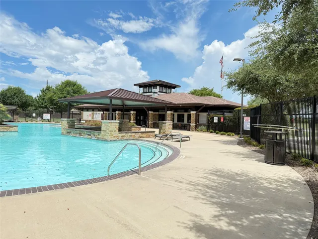 a view of a white house with a swimming pool and a yard