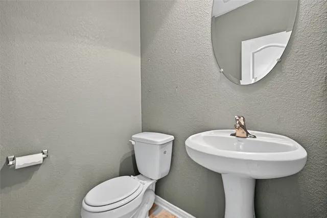 a bathroom with a toilet a sink and mirror