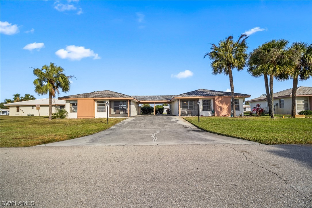 1609 Ridgecrest Street Lehigh Acres, FL 33936 - Photo 18 of 20 a front view of house with yard and green space