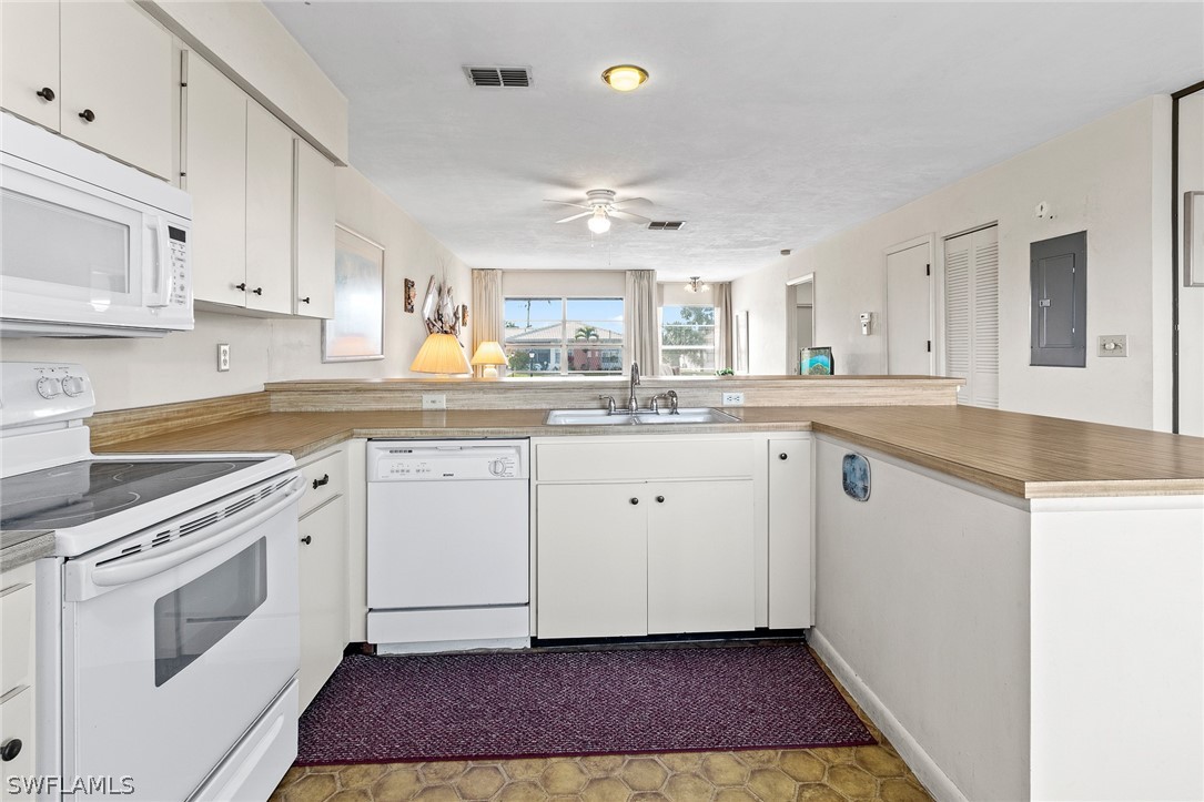 1609 Ridgecrest Street Lehigh Acres, FL 33936 - Photo 6 of 20 a kitchen with a white cabinets stove and sink