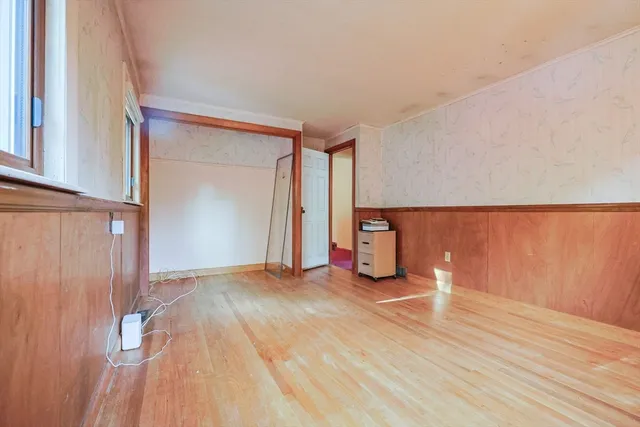 a view of empty room with wooden floor