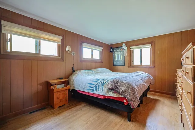 a bedroom with a bed and windows