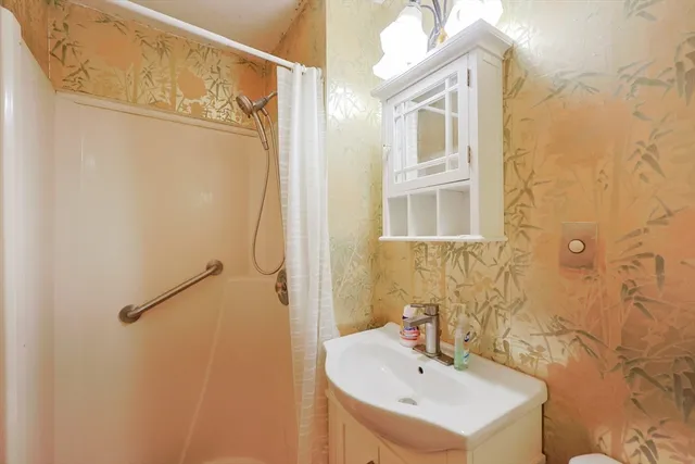 a bathroom with a sink a mirror and a shower