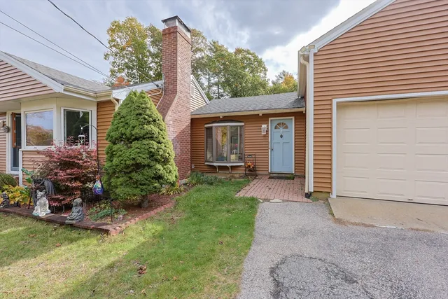 front view of house with a yard and potted plants