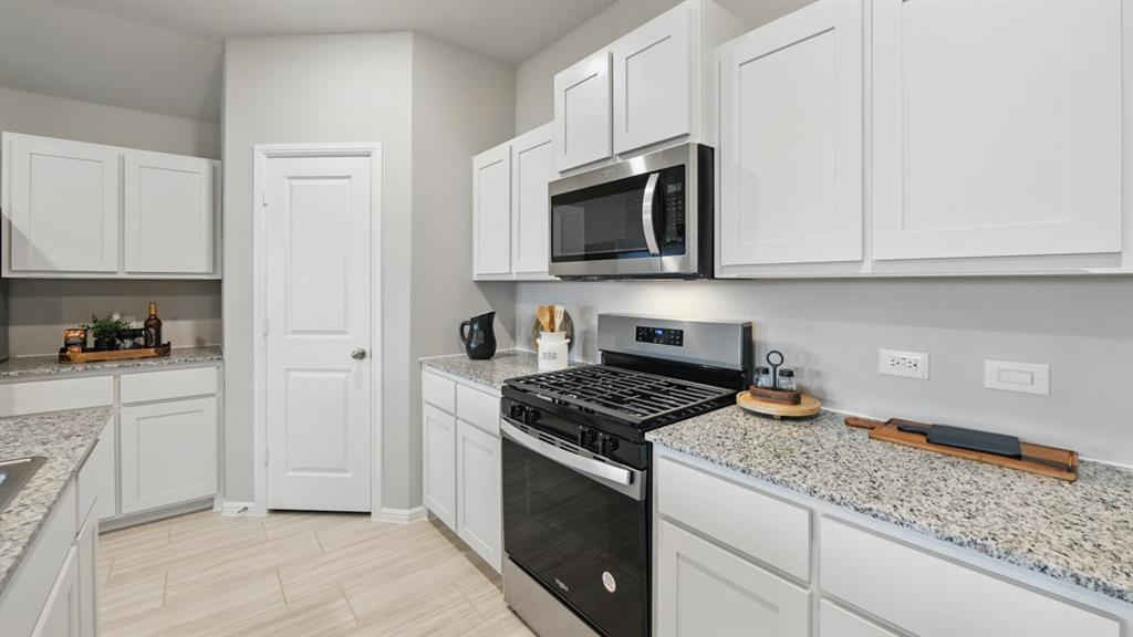 1505 Cansler Drive Krum, TX 76249 - Photo 2 of 39 a kitchen with stainless steel appliances granite countertop white cabinets and a stove a sink