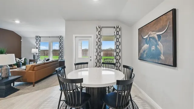 a view of a dining room with furniture and a kitchen