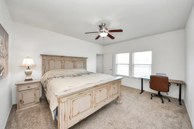 a bedroom with a bed a chair and a chandelier