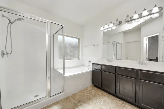 a spacious bathroom with a double vanity sink mirror and bathtub