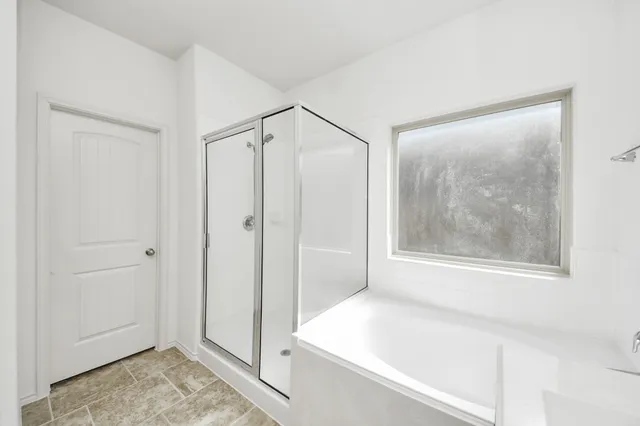 a spacious bathroom with a bathtub and a shower