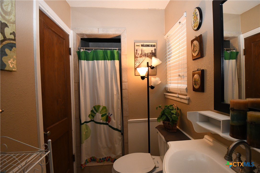 6019 Forest Ridge San Antonio, TX 78240 - Photo 18 of 25 a bathroom with a toilet a sink and mirror