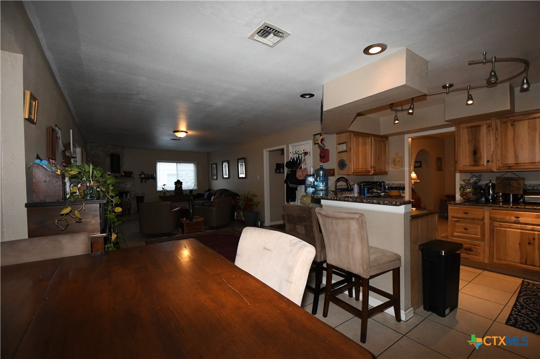 6019 Forest Ridge San Antonio, TX 78240 - Photo 9 of 25 a kitchen with stainless steel appliances kitchen island granite countertop a refrigerator a stove a sink dishwasher and a dining table with garden view