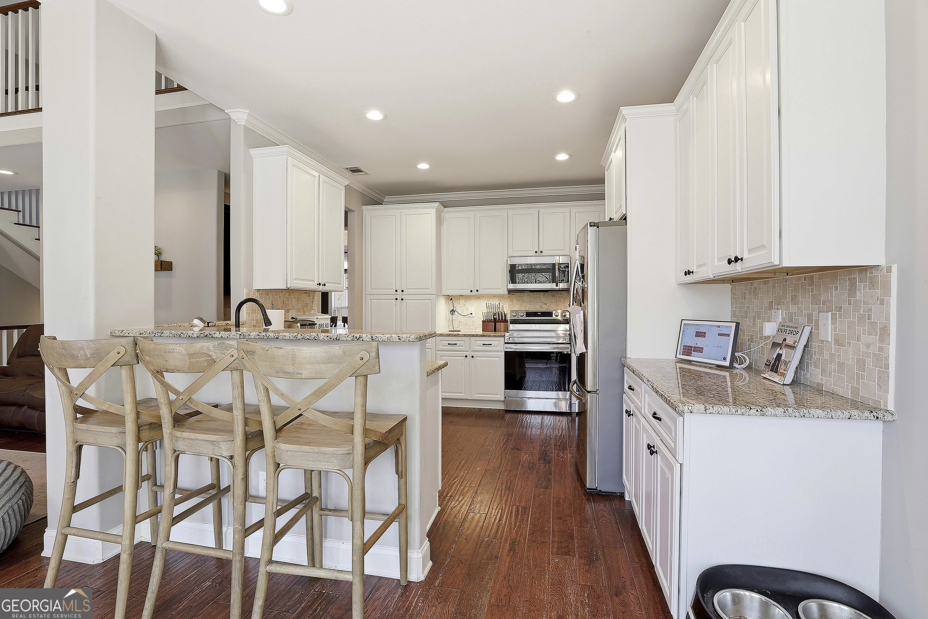 170 Emerson Ridge Trail Senoia, GA 30276 - Photo 22 of 24 a kitchen with stainless steel appliances kitchen island granite countertop a sink and cabinets
