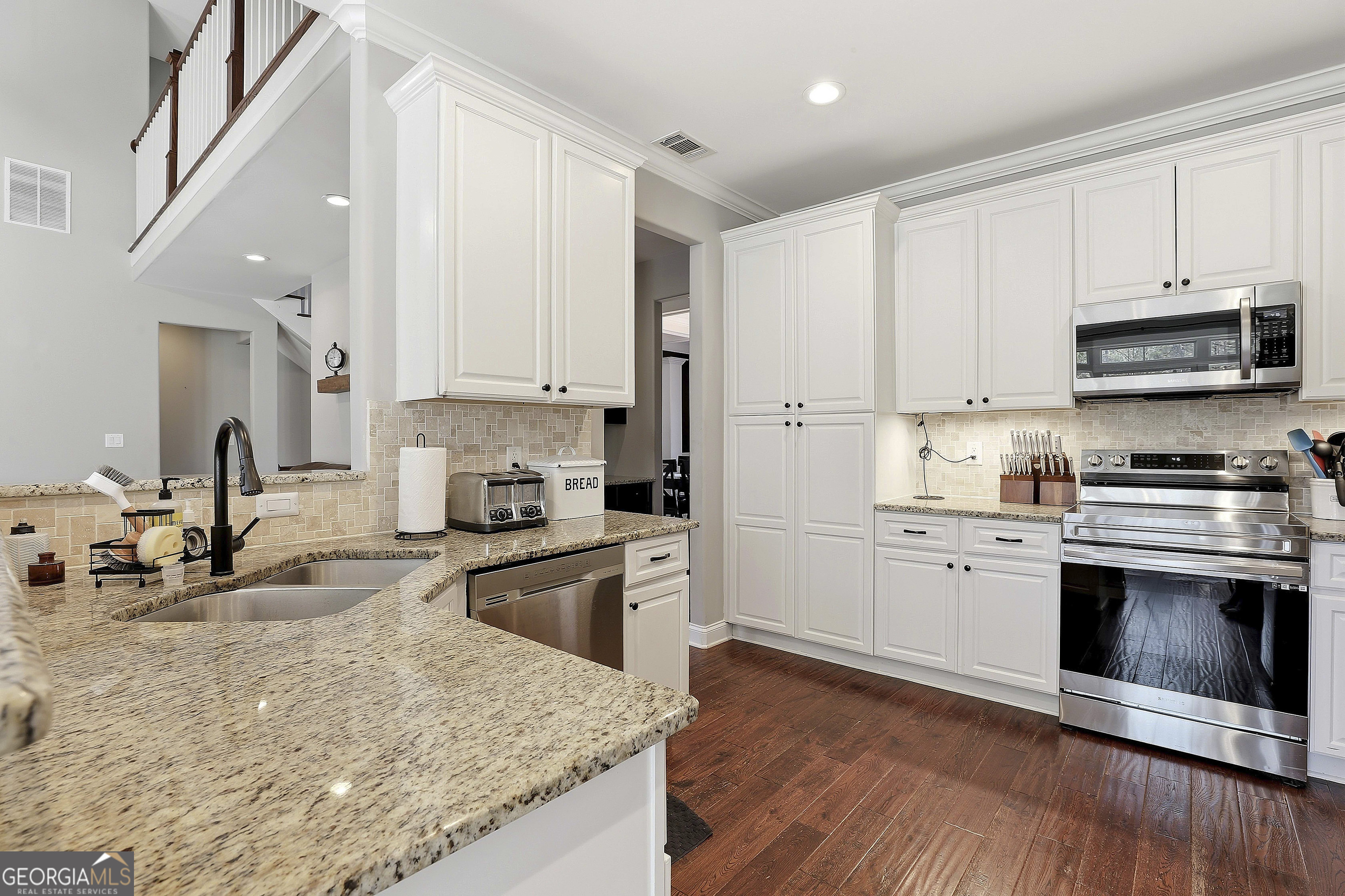 170 Emerson Ridge Trail Senoia, GA 30276 - Photo 23 of 24 a kitchen with granite countertop a stove sink and cabinets