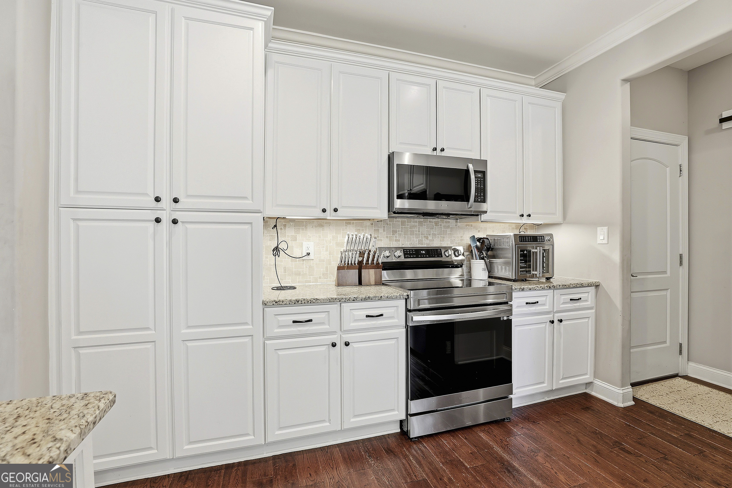 170 Emerson Ridge Trail Senoia, GA 30276 - Photo 24 of 24 a kitchen with white cabinets and stainless steel appliances
