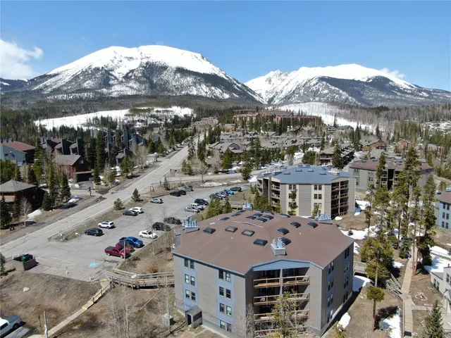a front view of a building with a mountain in the background