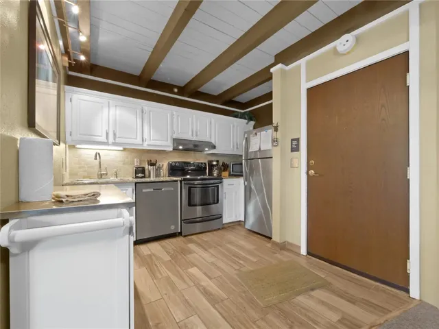 a kitchen with a refrigerator a stove top oven and cabinets