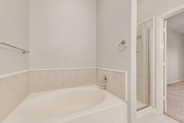 a white bath tub sitting next to a shower