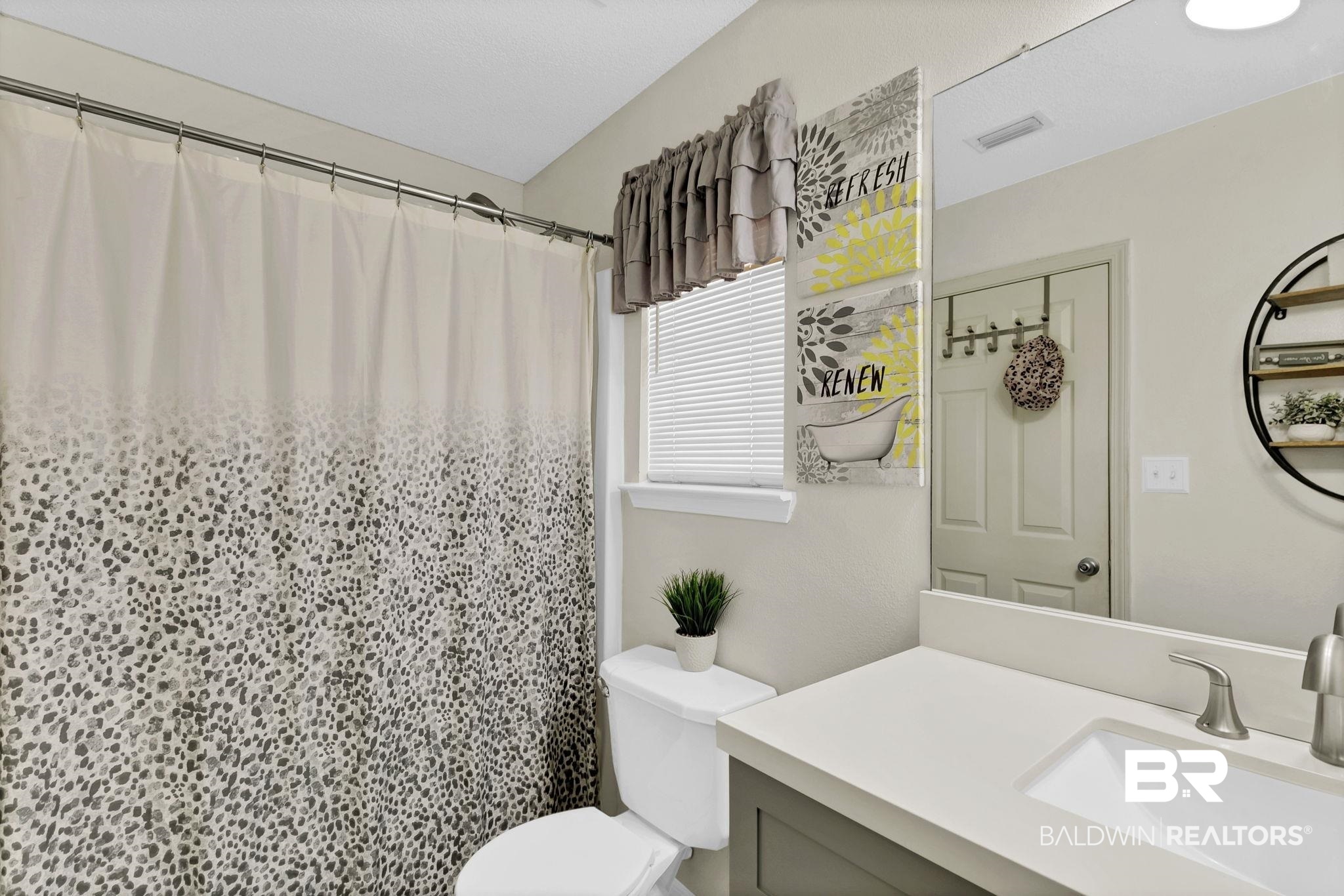 11103 Pontchartrain Loop Daphne, AL 36526 - Photo 24 of 29 Full bath featuring visible vents, curtained shower, toilet, and vanity