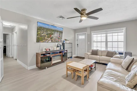 a living room with furniture kitchen view and a window