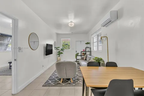 a living room with furniture a chandelier and a dining table