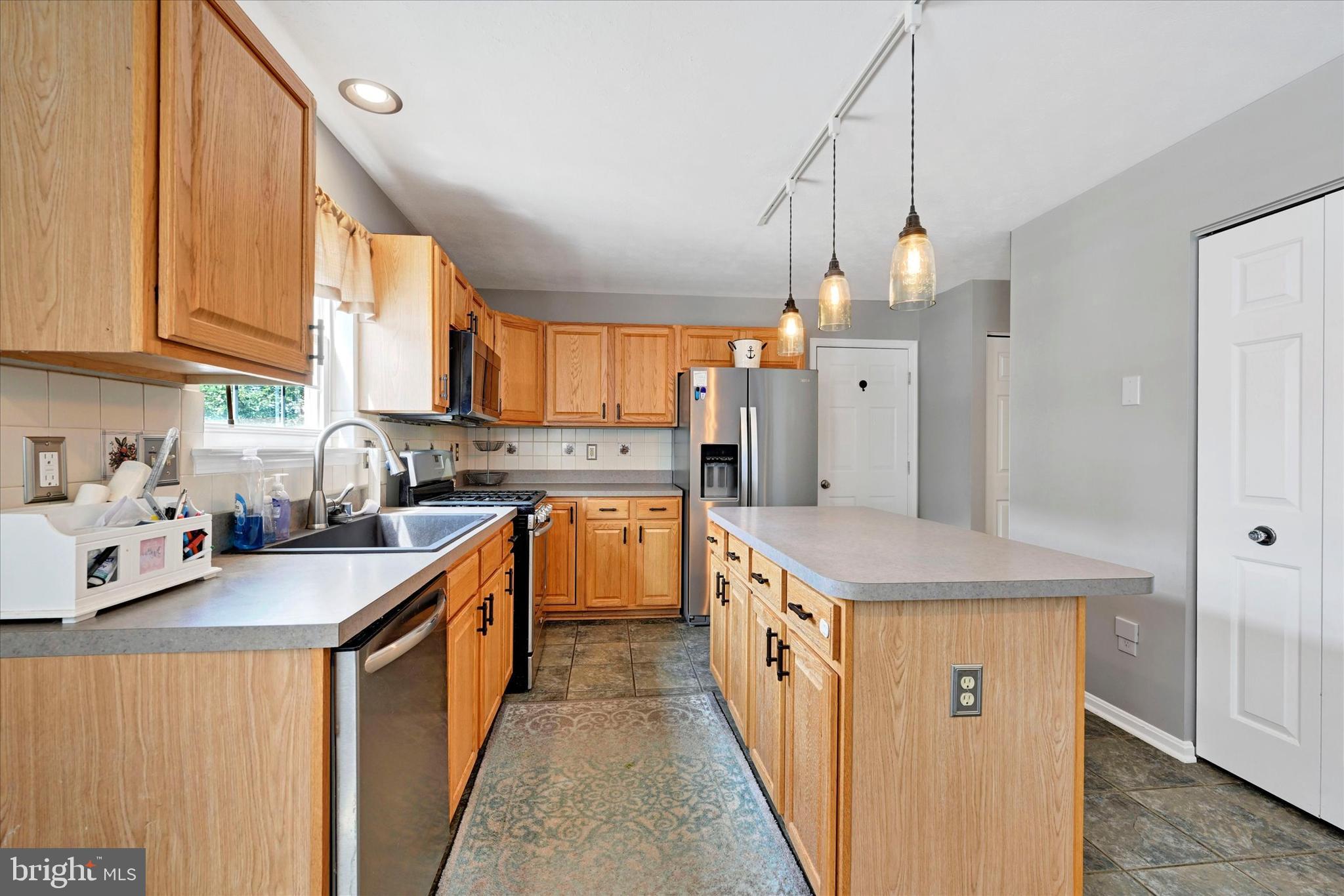 4195 Fallow Drive Hampstead, MD 21074 - Photo 13 of 40 a kitchen with stainless steel appliances granite countertop a sink a stove and a refrigerator